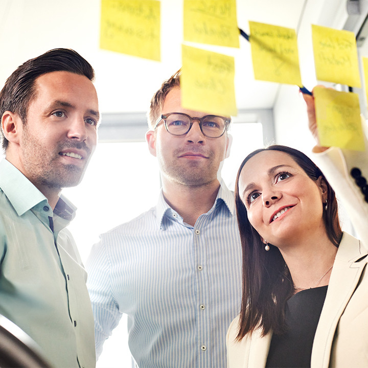 TriFinance Workshop zur Prozessoptimierung: Drei Finance-Experten analysieren Record to Report (R2R) Abl&auml;ufe mittels Post-its in einem modernen B&uuml;ro-Setting.